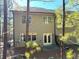 View of the rear exterior with a small patio and wooded views at 3275 Wild Basil Ln, Buford, GA 30519