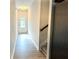 Inviting hallway with wood floors leading to a staircase and a sunlit doorway at 3275 Wild Basil Ln, Buford, GA 30519