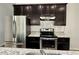Close-up kitchen view showcasing granite countertops, stainless steel appliances, and dark cabinetry at 3275 Wild Basil Ln, Buford, GA 30519