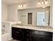 Main bathroom featuring a double vanity with granite counters and a large mirror at 3275 Wild Basil Ln, Buford, GA 30519
