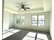Bright main bedroom features a ceiling fan and tray ceiling, with natural light from two large windows at 3275 Wild Basil Ln, Buford, GA 30519