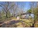 Spacious backyard featuring outbuildings amidst mature trees, offering potential for various uses at 5812 Dogwood Cir, Austell, GA 30168