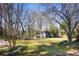 Large backyard with mature trees, green lawn, and an outbuilding, perfect for outdoor enjoyment at 5812 Dogwood Cir, Austell, GA 30168