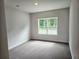 Cozy bedroom featuring neutral paint, plush carpet, and a bright window at 112 Scarlett Place Dr, Bowdon, GA 30108