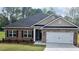 Charming one-story brick home with a two-car garage and well-manicured lawn, creating an inviting curb appeal at 112 Scarlett Place Dr, Bowdon, GA 30108
