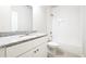 A well-lit bathroom featuring a single sink vanity, tile flooring, and a shower with a bathtub at 2076 Greenridge Se Rd, Smyrna, GA 30080