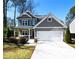 Charming two-story home featuring a covered front porch, gray siding, and a two-car garage at 2076 Greenridge Se Rd, Smyrna, GA 30080