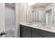Bathroom with dual sinks, gray cabinetry, and a tub with white tile surround at 333 Willow Cv, Canton, GA 30114