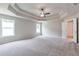 Spacious bedroom featuring a tray ceiling, ceiling fan, and plush carpeting at 333 Willow Cv, Canton, GA 30114
