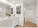 Bathroom featuring double sinks, modern fixtures, and a glass-enclosed shower with tiled flooring at 5523 Rosehall Pl, Atlanta, GA 30349