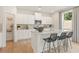 Modern kitchen with an island, stainless steel appliances, white cabinets, and wood-look floors at 5523 Rosehall Pl, Atlanta, GA 30349