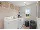 Functional laundry room with modern appliances, storage shelves, and accent decor at 5523 Rosehall Pl, Atlanta, GA 30349