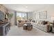 Living room area featuring a sectional sofa with decorative pillows, side tables, and large windows at 5523 Rosehall Pl, Atlanta, GA 30349