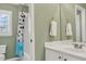 Bathroom featuring green walls, white vanity, mirror and tub/shower at 1129 Gavinwood Pl, Decatur, GA 30033