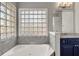 Bathroom with tub encased in marble with glass block window and a separate toilet room at 1129 Gavinwood Pl, Decatur, GA 30033
