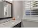 Bathroom featuring vanity with marble countertop, a mirror, and window with plantation shutters at 1129 Gavinwood Pl, Decatur, GA 30033