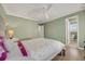 Bedroom features a ceiling fan, a bed with white and pink accents, light green walls, and a doorway to a bathroom at 1129 Gavinwood Pl, Decatur, GA 30033