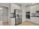 Bright kitchen features stainless steel appliances, white cabinets, and light hardwood floors at 1129 Gavinwood Pl, Decatur, GA 30033
