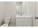 Well-lit bathroom featuring a sleek vanity, framed mirror, and a toilet with a white finish at 5527 Rosehall Pl, Atlanta, GA 30349