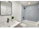 Updated bathroom featuring a bathtub, gray tile, and modern black fixtures at 151 Wilbur Ln, Lawrenceville, GA 30044
