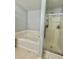 Bathroom features a luxurious soaking tub next to shower with glass door at 1552 Viero Dr, Lawrenceville, GA 30044