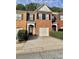 Two-story brick townhome featuring a one car garage and well-maintained landscaping at 1552 Viero Dr, Lawrenceville, GA 30044