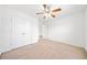 This bedroom features neutral carpet and a ceiling fan with a light, offering comfort and functionality at 28 Dover Commons Dr, Tucker, GA 30084