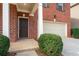 Close-up of the front door and garage of a charming red brick home at 28 Dover Commons Dr, Tucker, GA 30084