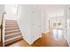 Hallway with wood floors, staircase, and a view into the backyard at 28 Dover Commons Dr, Tucker, GA 30084