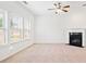 Bright open concept living room with fireplace, ceiling fan, and large windows at 28 Dover Commons Dr, Tucker, GA 30084