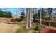 Wide backyard includes mulched garden areas, mature trees, and a wooden fence for privacy at 2899 Greystone Cv, Chamblee, GA 30341