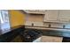 View of black JennAir cooktop set in black granite countertops with white cabinetry at 2899 Greystone Cv, Chamblee, GA 30341