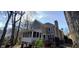 Rear exterior view of the house featuring a screened-in porch, wooden deck and wooded lot at 2899 Greystone Cv, Chamblee, GA 30341