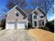 Two-story stucco home with an attached two-car garage and a well-manicured front lawn at 2899 Greystone Cv, Chamblee, GA 30341