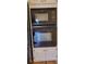 Built-in oven and microwave with white cabinets and hardwood floors at 2899 Greystone Cv, Chamblee, GA 30341