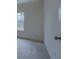 Bright bedroom with a window and light-colored carpet. Doorway is partially visible at 83 Malcom Rd, Covington, GA 30014