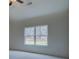 Bright bedroom with a large window showcasing a serene wooded view and a ceiling fan at 83 Malcom Rd, Covington, GA 30014