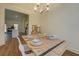 Bright dining room with wooden table set for four, modern lighting, and connected kitchen area at 83 Malcom Rd, Covington, GA 30014
