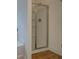 Modern bathroom shower with glass doors and chrome fixtures on wood-look flooring at 83 Malcom Rd, Covington, GA 30014