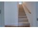 Carpeted staircase with a wooden handrail and white walls, leading to the upper level at 83 Malcom Rd, Covington, GA 30014