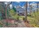 Landscaped backyard with grassy yard, bench, walking path, and beautiful two-story home in the background at 1194 Kendrick Ne Rd, Atlanta, GA 30319