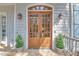 Elegant double front doors with glass panels flanked by sconces, potted shrubs and stone tile entry at 1194 Kendrick Ne Rd, Atlanta, GA 30319