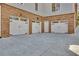 Three-car garage with carriage doors and brick exterior with a concrete driveway at 1194 Kendrick Ne Rd, Atlanta, GA 30319