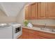 Laundry room with wooden cabinetry, sink, granite countertop, washer and dryer at 1194 Kendrick Ne Rd, Atlanta, GA 30319