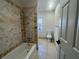 Bathroom with tiled tub and shower, along with a toilet and window providing natural light at 2911 Bentwood Dr, Marietta, GA 30062