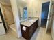 Granite-topped vanity with dark wood cabinets, sink, mirror, and tiled flooring in bathroom at 2911 Bentwood Dr, Marietta, GA 30062
