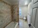 Bright bathroom featuring a tiled shower-tub, toilet, and neutral tile flooring at 2911 Bentwood Dr, Marietta, GA 30062