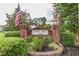 Brick entrance to Saddle Ridge Lake community with American flags and lush greenery, showcasing a welcoming environment at 2911 Bentwood Dr, Marietta, GA 30062