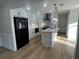 Well-lit kitchen with white cabinets, marble backsplash, black appliances, island with sink, and wood floors at 2911 Bentwood Dr, Marietta, GA 30062