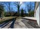 View of a concrete patio in a backyard with trees and lawn, adjacent to the house at 3512 Fairlane Nw Dr, Atlanta, GA 30331